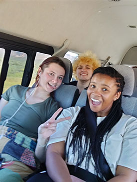 Students in a vehicle pose and smile during their study abroad in Cape Town, South Africa.