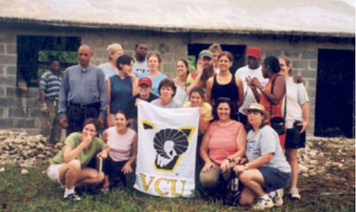 School of Social Work students in Palamara, Dominican Republic, holding a white V-C-U flag with ram head