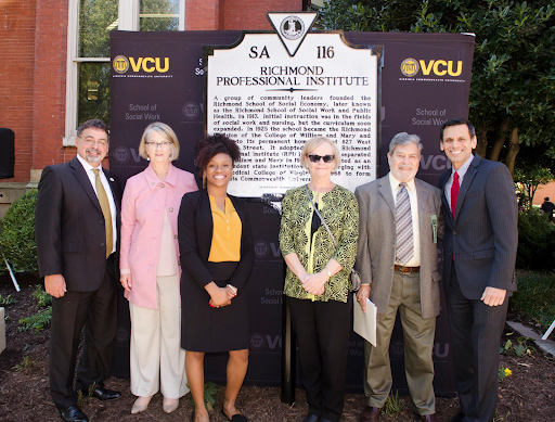 Social Work dean Timothy Davey (far left) and V-C-U President Michael Rao (far right), stand with members of the social work community in front of the commemorative highway marker celebrating the School of Social Work's 100th anniversary on Oct. 4, 2017