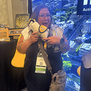 A raffle winner holds a stuffed Rodney the Ram.